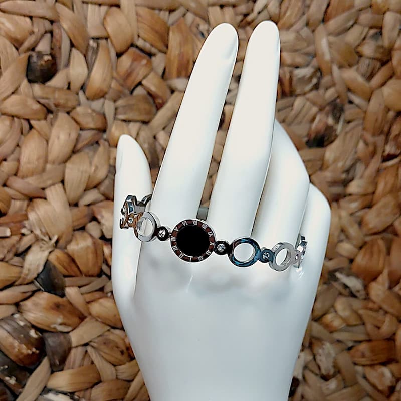 Pulsera mujer acero plateado rigida con circulos y un circulo nacar negro y numeros romanos