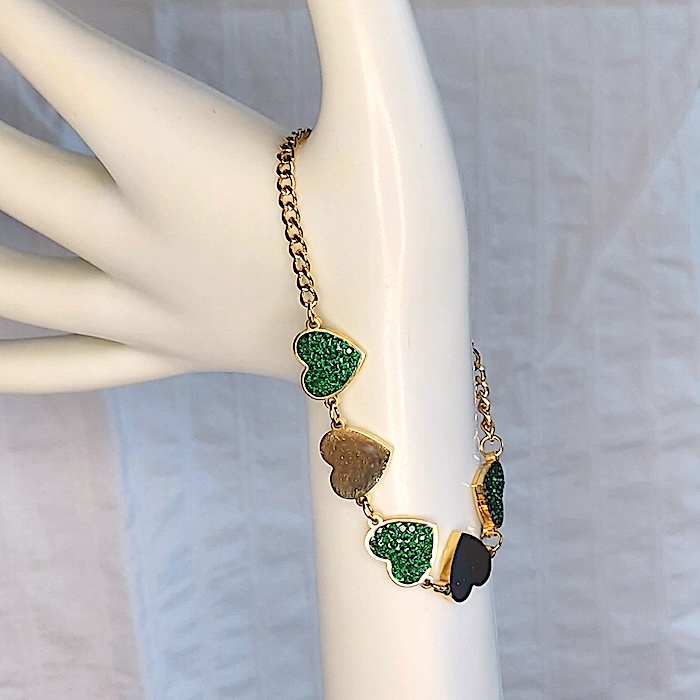 Maniquí con pulsera dorada con corazones de circonitas verdes